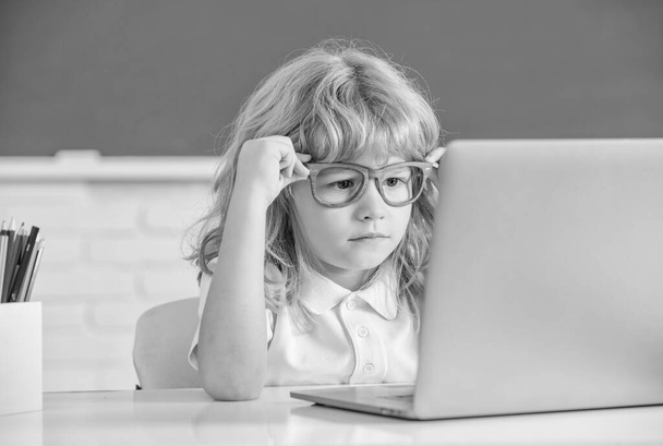 Smart Nerd Kind mit Brille und Laptop. 1. September E-Learning. Kind lernt am Computer. Teenager-Junge im Klassenzimmer. zurück zur Schule. Wissenstag. Konzept der Online-Bildung. - Foto, Bild