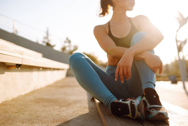 Young woman in sports outfit doing exercises outdoors in the morning. Sport woman doing stretching exercise. Sport, Active life, sports training, healthy lifestyle. - Fotografie, Obrázek