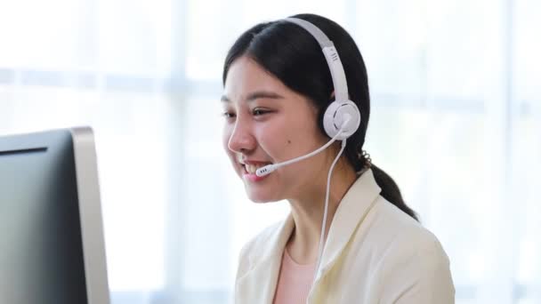 Mooie Aziatische vrouw, ze is een call center werknemer van een internet-en telefoonbedrijf, ze is verantwoordelijk voor het verstrekken van service en bijstand aan klanten via de telefoon. Call center concept. - Video