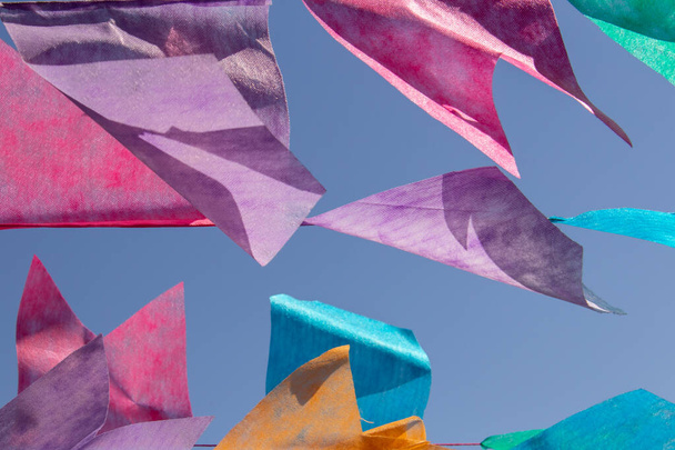 Varios banderines de colores colgando en el tendedero con el cielo azul en el fondo. Festa Junina. Quadrilha. - Foto, imagen