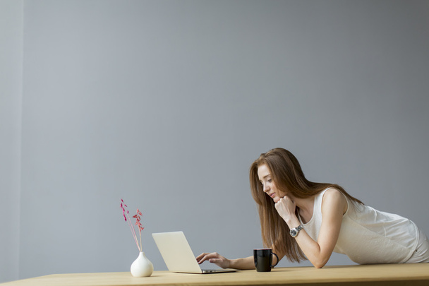 молода жінка з ноутбуком в офісі
 - Фото, зображення