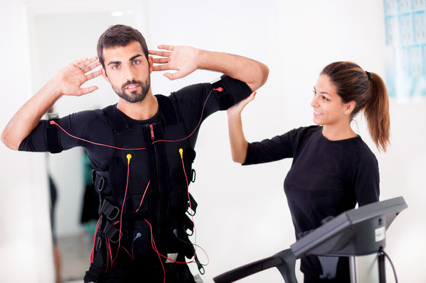  Female coach giving man ems electro muscular stimulation exerci - Photo, Image