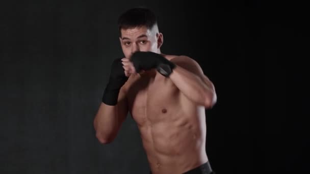 Fiatal félmeztelen férfi bokszoló mutatja a mozdulatait. Középső felvétel - Felvétel, videó