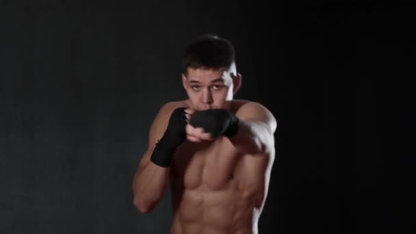 Fiatal, félmeztelen férfi bokszoló mozdulatokkal. Középső felvétel - Felvétel, videó