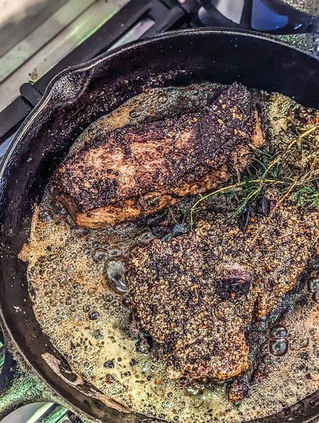 basting premium steak on iron pan on stove - Photo, Image