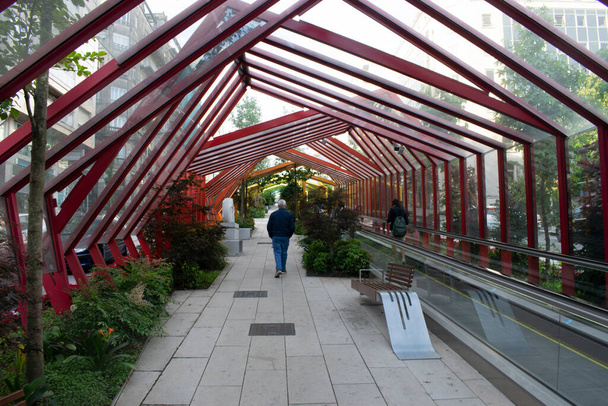 Glazed walkway in a park with gardens. - 写真・画像