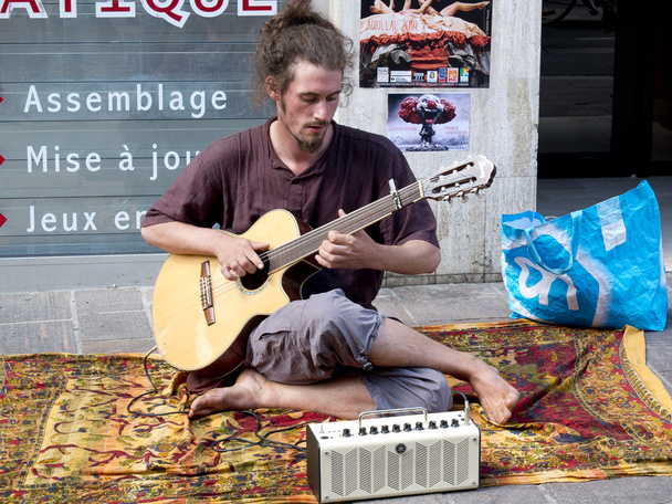 Босоніж і волохаті музикант, грає на гітарі на вулиці. - Фото, зображення