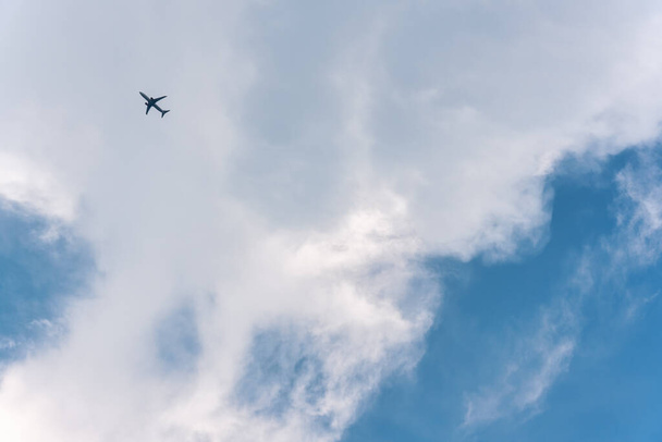 Repülő repülőgép az égen, fehér felhőkkel nappal. - Fotó, kép