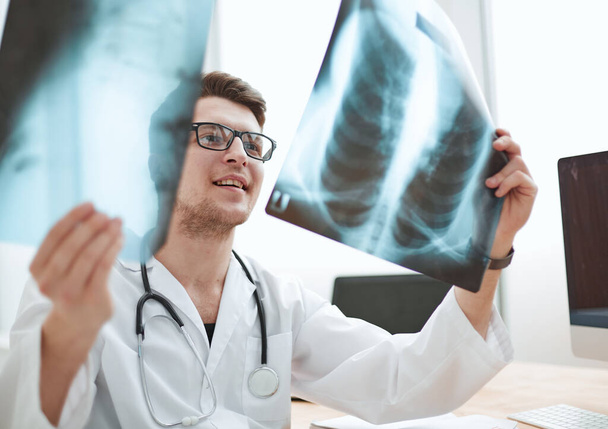 Чоловік-лікар у скляному радіологів вивчає рентгенівські промені в медичному кабінеті
. - Фото, зображення