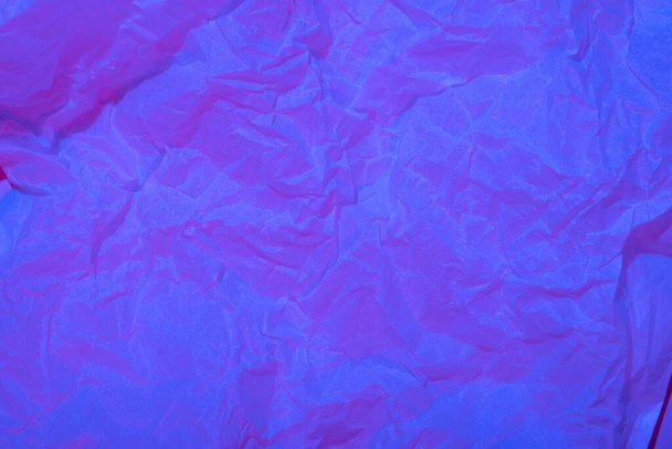 Abstract crumpled paper background in neon light. - Photo, Image