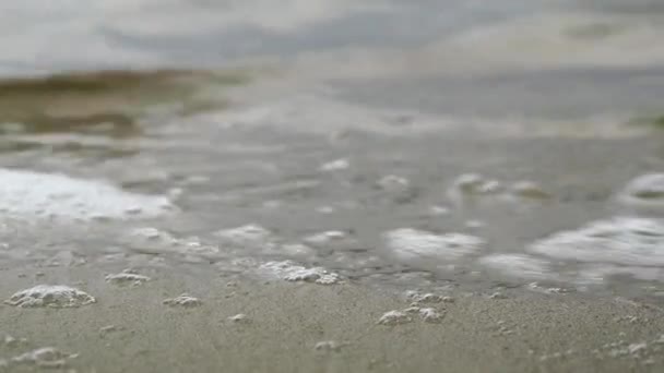 Su, deniz kumu üzerinde yuvarlanıyor. Yüksek kalite 4k görüntü - Video, Çekim