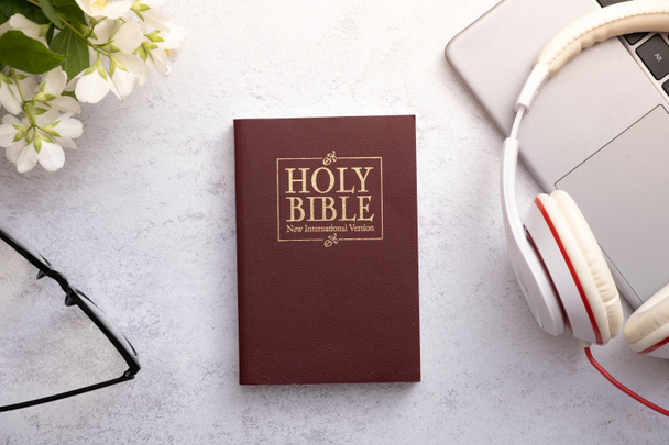 Top Pohled na Bibli svatou na pracovním stole se sluchátky. Bible online koncept - Fotografie, Obrázek