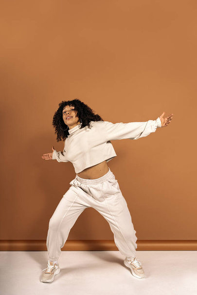 Stock photo of cool african american dancer posing in studio shot against brown background. - Фото, изображение