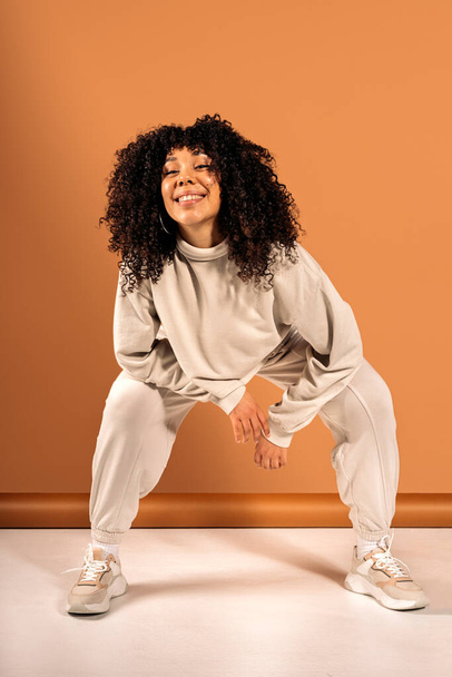 Stock photo of cool african american dancer posing in studio shot against brown background. - Foto, immagini