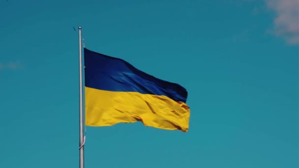 Wielka żółto-niebieska ukraińska flaga macha na wietrze w zwolnionym tempie jako symbol niepodległości i siły Ukrainy. Rosyjska inwazja wojenna na Ukrainie. Stań z Ukrainą - Materiał filmowy, wideo