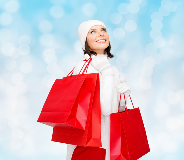 smiling young woman with red shopping bags - 写真・画像
