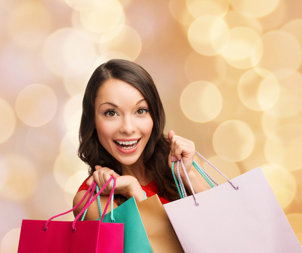 Lachende vrouw met kleurrijke shopping tassen - Foto, afbeelding