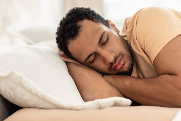İyi uykular. Arap Adam, sıcak yatak odasında uyuyarak el ele uyuyor. Erkek, evde yatakta dinlenirken, yakın çekimde çekilmiş. Dinlenme, Dinlenme ve Dinlenme Konsepti - Fotoğraf, Görsel