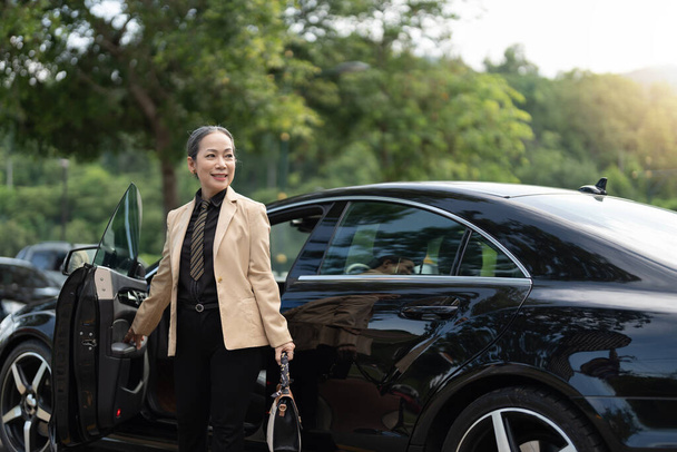 Asiatique mature entreprise succès femme débarquer de la voiture de luxe. - Photo, image