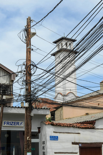 Ángulo de cables eléctricos en un pilón frente a una casa en Prizren, Kosovo - Foto, Imagen