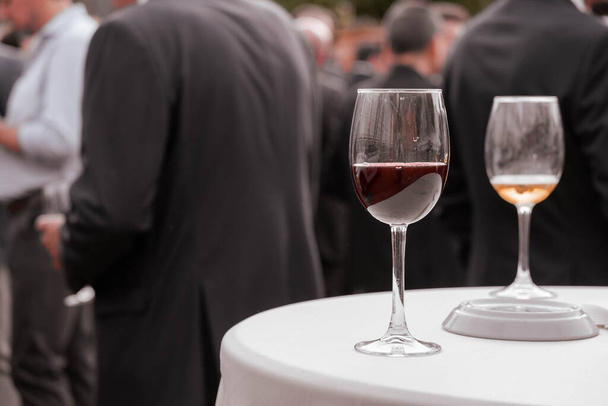 Um copo de vinho numa mesa de catering. Eventos ao ar livre, reuniões de amigos, eventos de trabalho. - Foto, Imagem