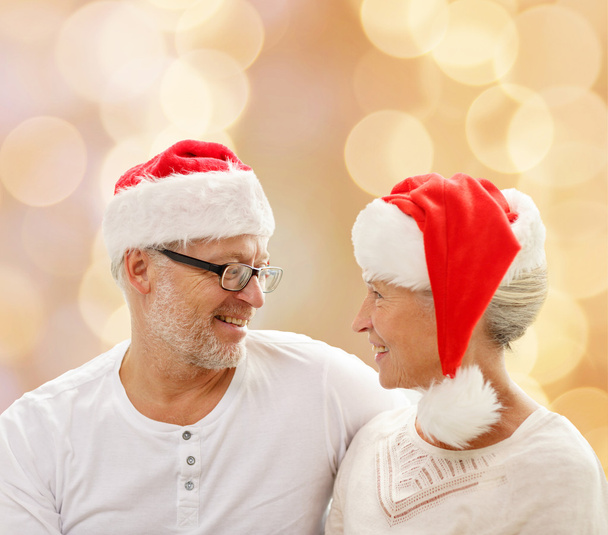 happy senior couple in santa helper hats - Фото, изображение