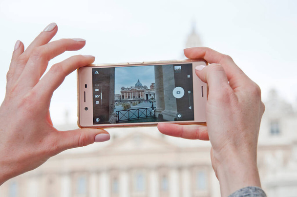 Mani che fotografano la Basilica di San Pietro in Vaticano su smartphone, Italia. - Foto, immagini
