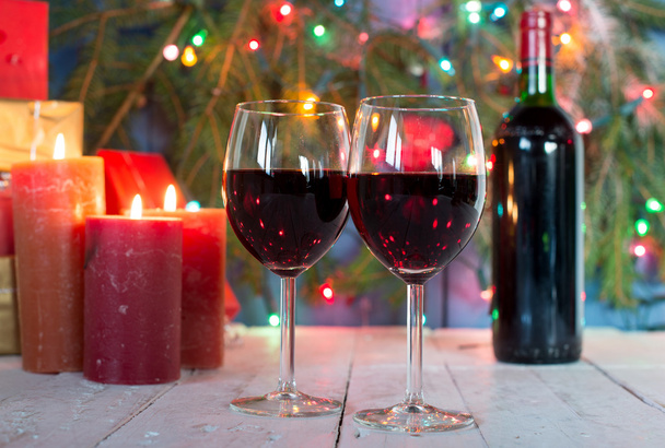 クリスマスの装飾と赤ワインのグラス - 写真・画像