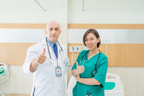 Orvos és nővér portréja, amint a kórházban a kamera előtt pózolnak és mosolyognak.. - Fotó, kép