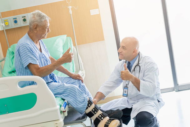 Ein Arzt untersucht den Kopf einer Patientin mit Knieproblemen im Krankenhaus. - Foto, Bild