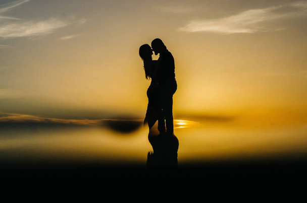 силует люблячої пари, що приймає на заході сонця
 - Фото, зображення