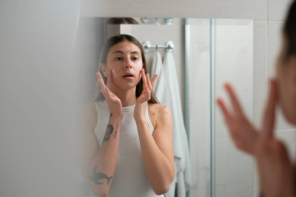 meisje doet schoonheid behandeling in badkamer - Foto, afbeelding