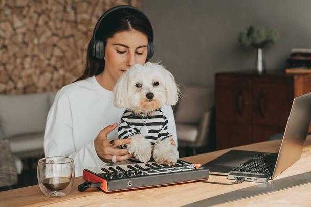 Zeneszerzés midi billentyűzeten kutyával máltai - Fotó, kép