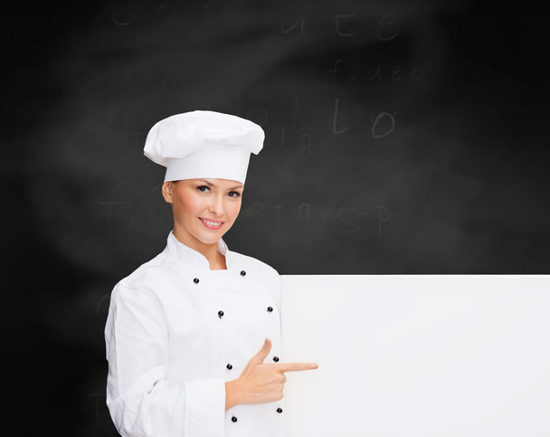 smiling female chef with white blank board - Фото, зображення
