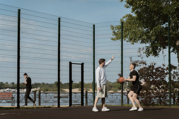 two guys play basketball outdoors on the court - Photo, Image