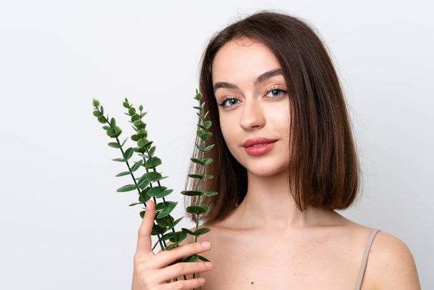 Young Ukrainian woman isolated on white background holding a eucalyptus branch. Close up portrait - Foto, Imagem