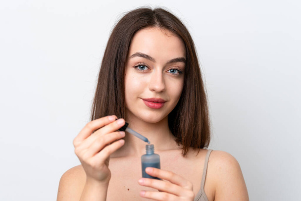 Young Ukrainian woman isolated on white background holding a serum. Close up portrait - Foto, imagen