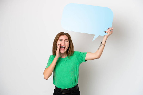 Young English woman isolated on white background holding an empty speech bubble and shouting - Photo, Image