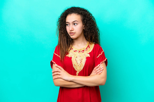 Young Arab woman isolated on blue background keeping the arms crossed - Photo, Image