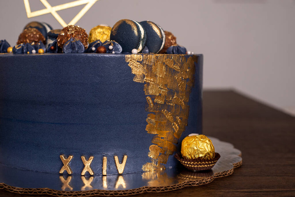 Gyönyörű kék torta, makarónival díszítve. Tizenöt születésnapi torta makarónival és csokoládéval díszítve. - Fotó, kép