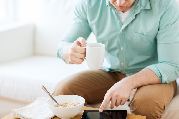 close up of man with tablet pc having breakfast - 写真・画像