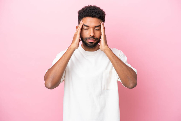 Young Brazilian man isolated on pink background with headache - Photo, Image