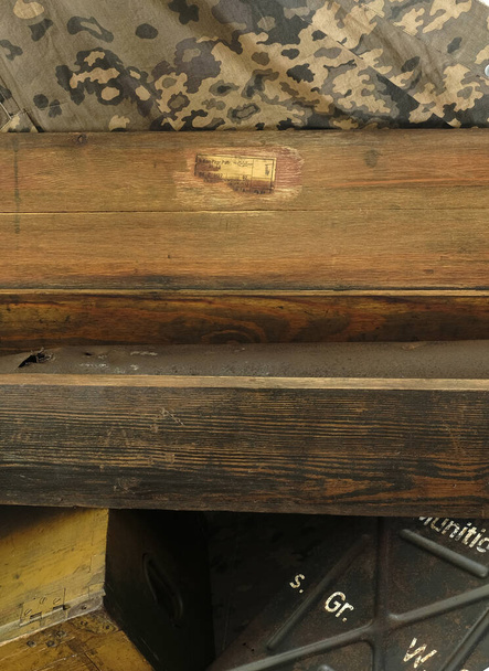 Caja de cañón antitanque de madera con una pegatina de papel sobre un fondo de tienda de camuflaje - Foto, Imagen