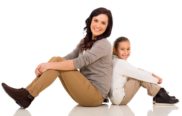 mother and daughter sitting back to back - Photo, Image