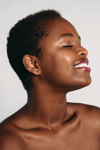 プロフィール、肉眼で彼女の完璧な肌を楽しんで魅力的なアフロ女性の半分の顔の肖像画、白い背景の上にポーズ。スパボディケア｜Cosmetology - 写真・画像