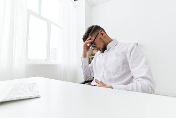 homens de negócios em uma camisa branca senta-se em um computador com um escritório de telefone. Foto de alta qualidade - Foto, Imagem