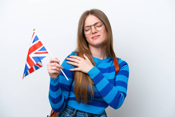 Young caucasian woman holding an United Kingdom flag isolated on white background suffering from pain in shoulder for having made an effort - Foto, immagini