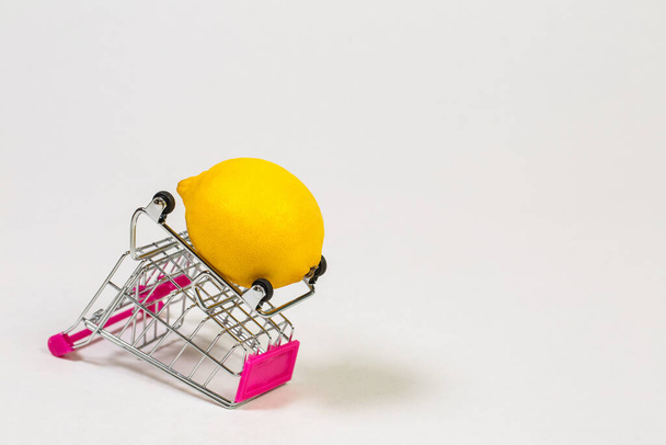 Lemon in a grocery trolley on a white background - Φωτογραφία, εικόνα