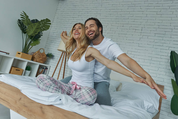 Heureux jeune couple profiter du temps dans le lit ensemble - Photo, image