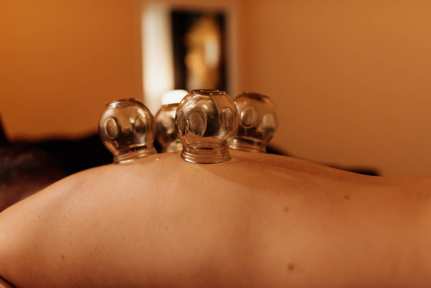 pacjent z przyssawkami na plecach na regenerację mięśni podczas zabiegu w centrum masażu i odnowy biologicznej - Zdjęcie, obraz